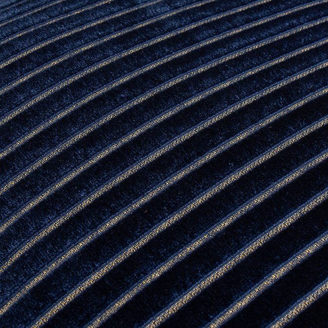close up image of navy blue cushion with gold stripe detail pattern