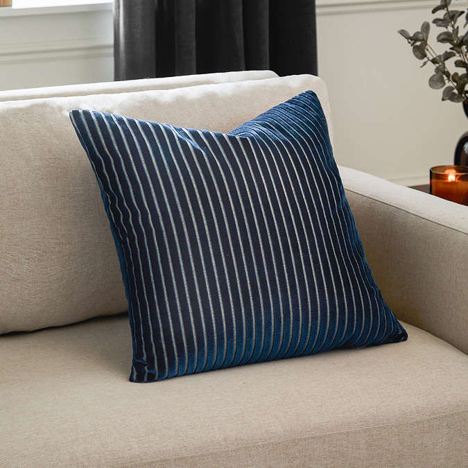 55x55cm navy blue cushion with vertical stripe detail, sat in corner of cream sofa