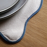 close up image of blue scalloped edge of cream placemat