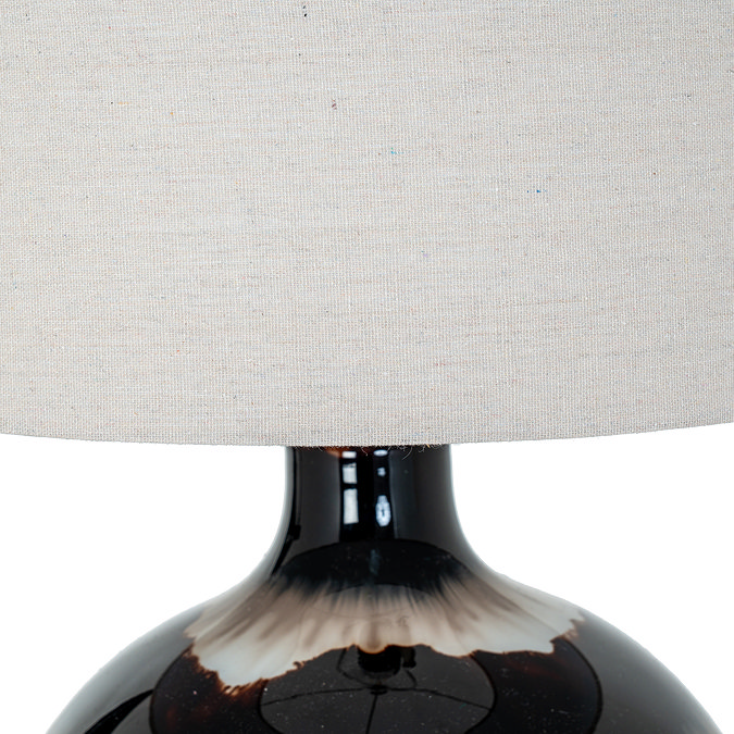 close up on linen shade of brown glass lamp
