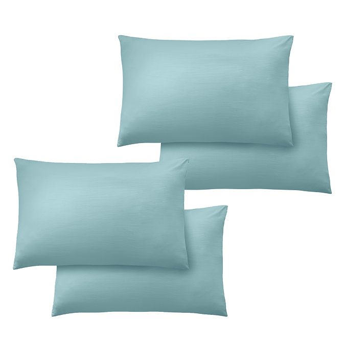 image cut out on white background of four duck egg blue pillowcases over pillows