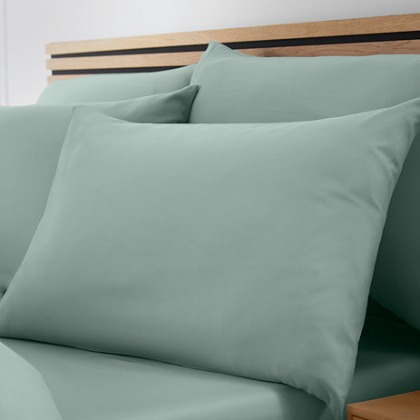 set of 4 light green pillowcases on bed with matching fitted sheet