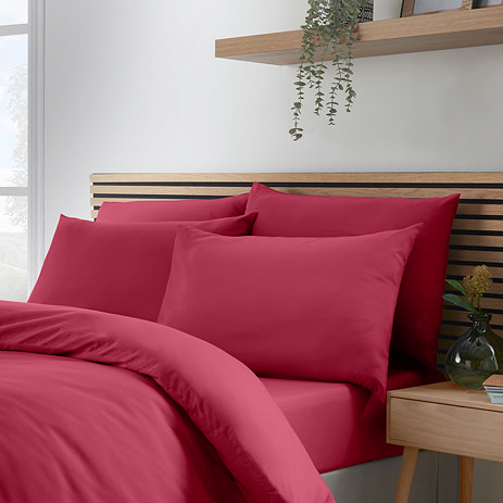 set of 4 hot pink pillowcases on bed with matching duvet and fitted sheet