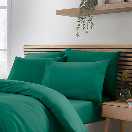 4 pillows with teal green pillowcases on bed