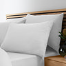 image of four pillows in white pillowcases on bed with matching duvet and fitted sheet