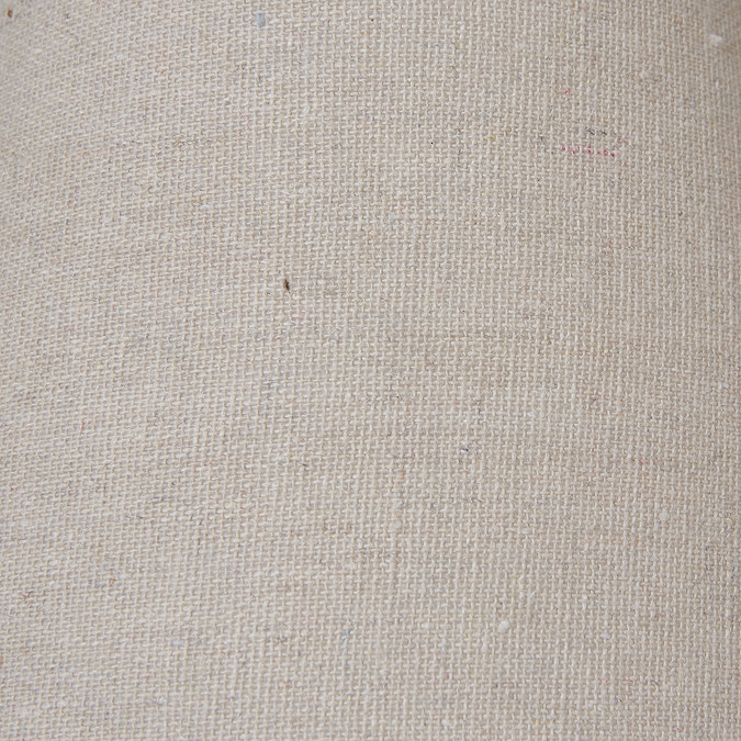 close up image of natural coloured linen shade on top of weathered-grey lamp