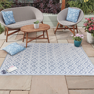 image of geometric diamond pattern rug in slate grey-blue and white, on a patio