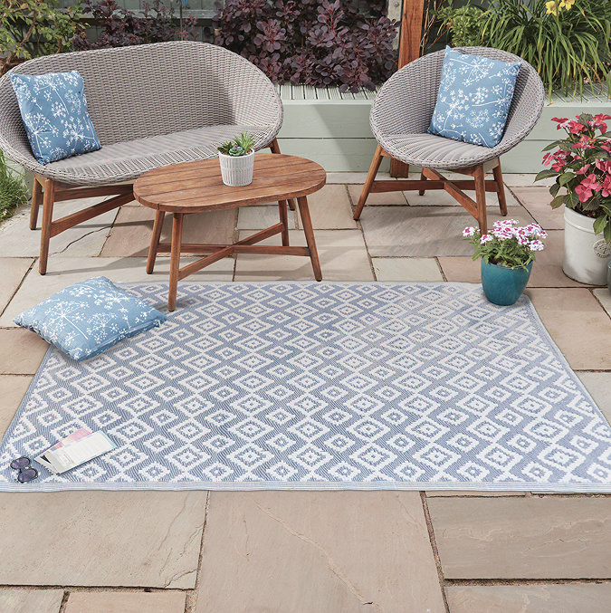 image of geometric diamond pattern rug in slate grey-blue and white, on a patio