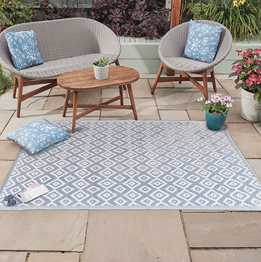 image cut out on white background of slate grey-blue and white geometric rug, laid flat