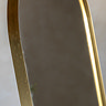close up on gold rounded edges of cheval floor mirror