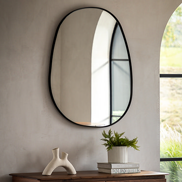 close up on smooth black edges of pebble shaped wall mirror