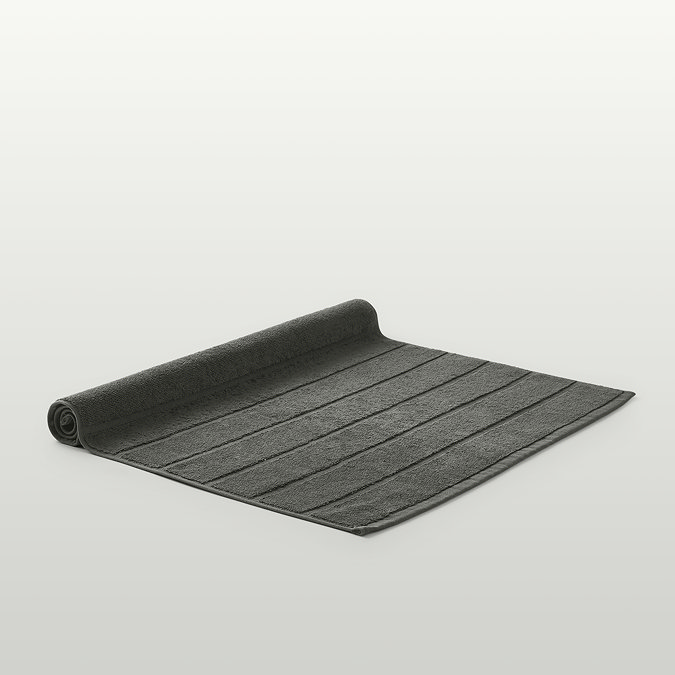 image of ash grey bath mat with end slightly rolled over, on light grey background