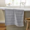 image of light grey bath mat hanging over side of bath