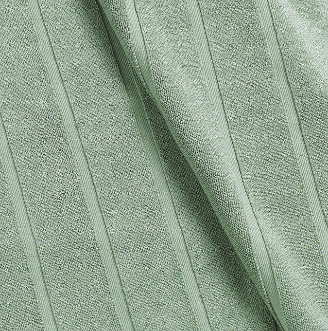 close up on texture and colour of jade green cotton a bath mat with striped detailing
