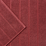 close up on wide ribbed texture of light red bath mat