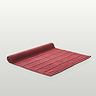 image of light red bath mat slightly rolled up at the end, on light grey background