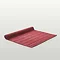 image of light red bath mat slightly rolled up at the end, on light grey background