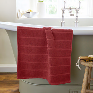 image of light red bath mat over side of bath