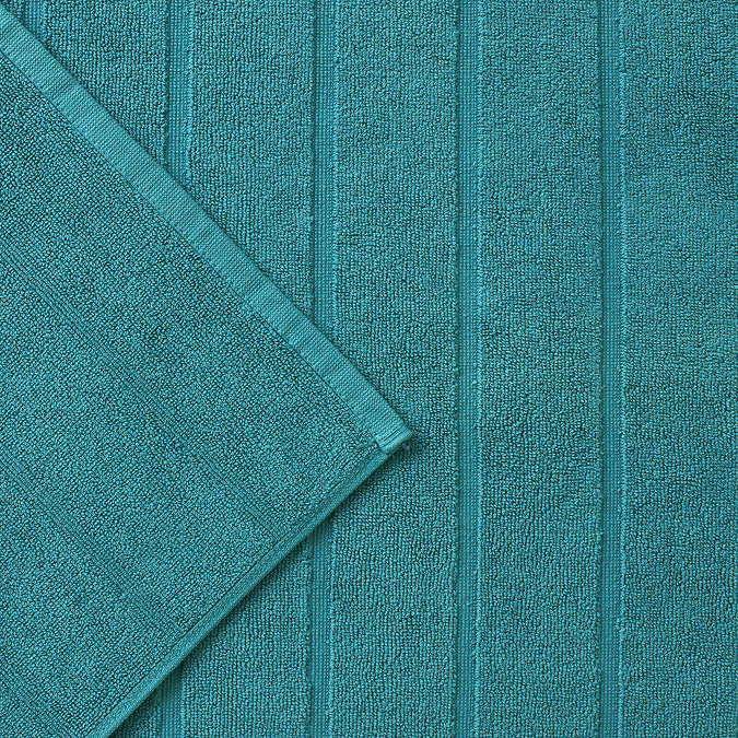 close up on texture and colour of vivid teal bath mat with stripe detailing