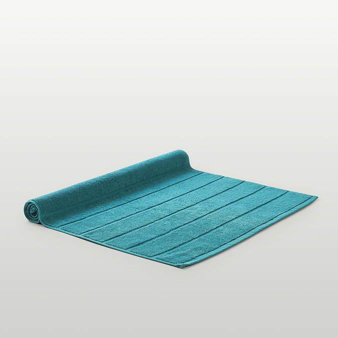 image of teal blue bath mat flat on light grey background