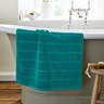 image of teal blue bath mat over the side of a bath