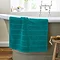 image of teal blue bath mat over the side of a bath