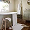 wide shot of bathroom full of white cotton towels, with matching bath mat on floor