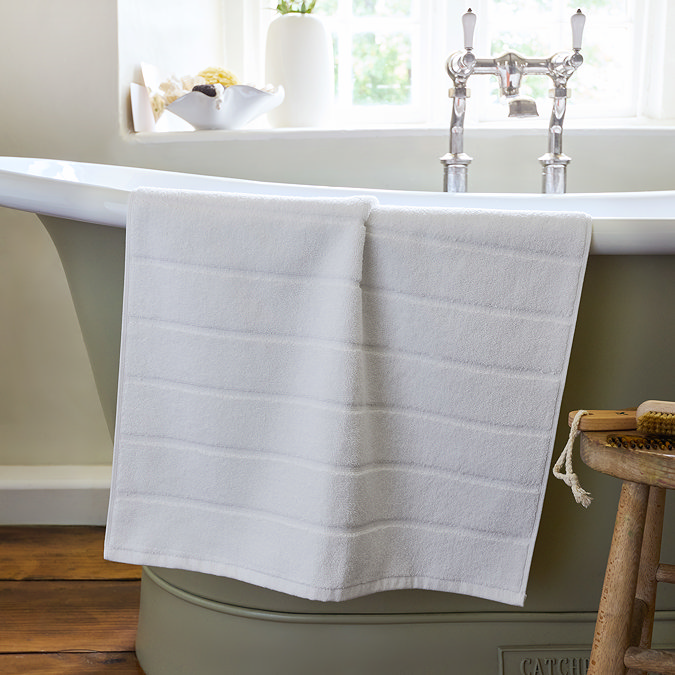 image of white bath mat draped over the side of a bath