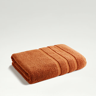 amber coloured towel folded on light grey background