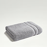 light grey towel folded on even lighter green background