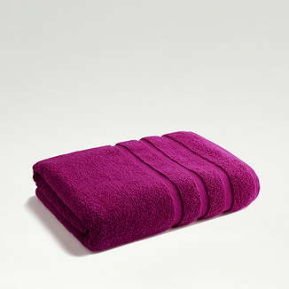 image of plum purple towel folded on light grey background