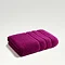 image of plum purple towel folded on light grey background
