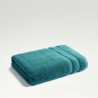 teal towel folded up on light grey background