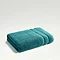 teal towel folded up on light grey background