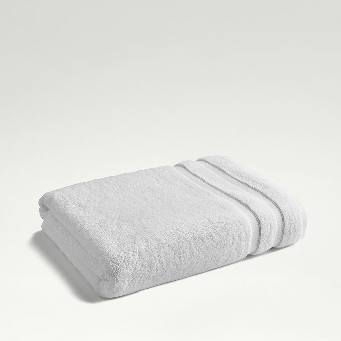white towel folded up on light grey background