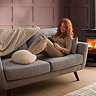 image of woman reclining on sofa with feet in boucle heated foot warmer