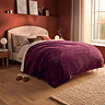 image of large burgundy red blanket covering a bed on top of duvet, with brown and orange cushions
