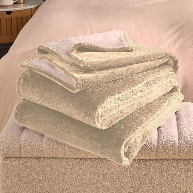 natural coloured plush blanket folded on the arm of a cream sofa
