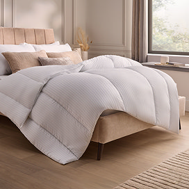 thick uncovered duvet atop a bed with pillows