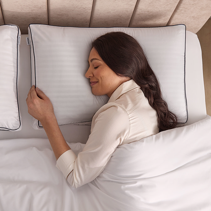 above image of a woman lying on her side with head resting on box pillow