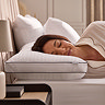 side image of woman resting her head on box pillow