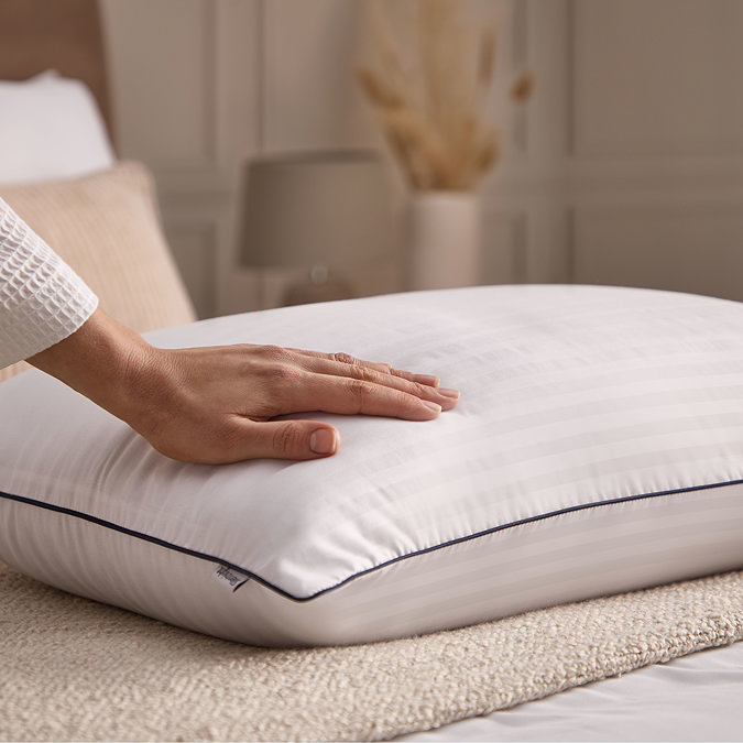 close up on person touching hotel white pillow