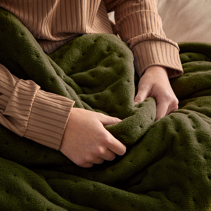 close up image of heated throw olive green colour and stitched channel design, for even heat distribution