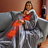 closer image of woman wearing large grey blanket, with graphic of heatwaves across body to indicated heated features