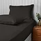 two black pillowcases on pillows at the head of a bed, one stood upright and one led flat on top of the matching black fitted sheet