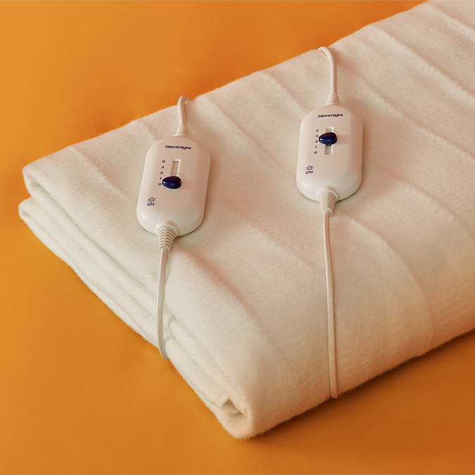 close up on folded yours and mine cream blanket on orange blanket, displaying two separate controllers
