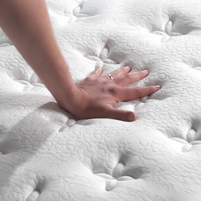close up on mattress fabric with hand touching it