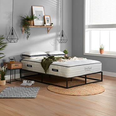 front-on image of deep mattress on a black frame against light grey wall