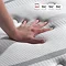 image of top of mattress with hand pressed down on it to feel texture and firmness