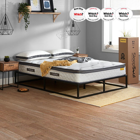 image of double mattress on black bedframe against light grey wall with mustard throw on top and box packaging stood up to the right of the window